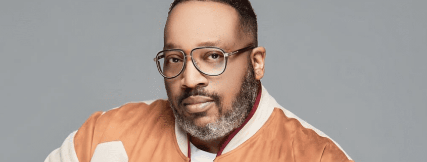 Man in glasses with an orange jacket.